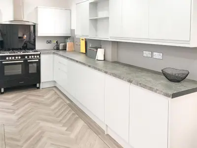 a kitchen with white cabinets and a counter top at Wendover in Keswick