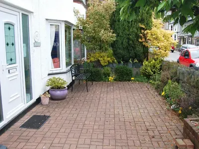 a patio with a bench in front of a house at Wendover in Keswick