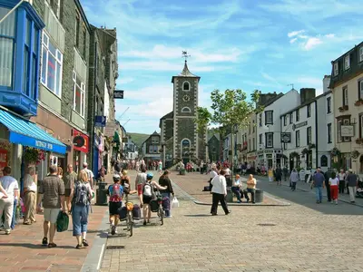 a crowd of people walking down a street with a clock tower at Fell View Lodge in Keswick