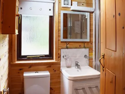 a bathroom with a sink and a toilet and a window at Ashness in Keswick