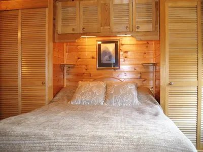 a bedroom with a bed in a wooden cabin at Acorn Lodge - Burnside Park in Keswick