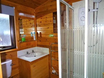 a bathroom with a shower and a sink and a toilet at Bewick Lodge in Keswick