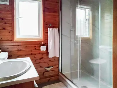 a bathroom with a glass shower and a sink at Bewick Lodge in Keswick