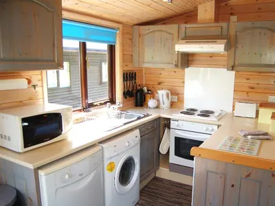 a kitchen with a washer and dryer in a cabin at Whinny Brow - Burnside Park in Keswick
