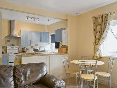 a kitchen with a couch and a table and chairs at Serendipity in Keswick