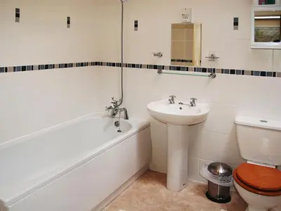 a bathroom with a sink and a tub and a toilet at Serendipity in Keswick