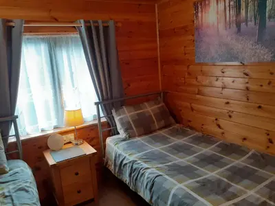 a bedroom with a bed and a lamp on a table at Ewe How - Burnside Park in Keswick