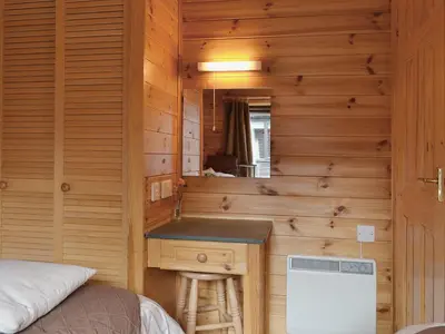 a bedroom with a vanity and a sink in a wooden wall at Ewe How - Burnside Park in Keswick