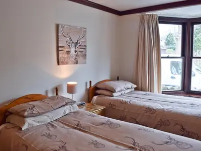 a bedroom with two beds and a window at Dairy Lodge in Keswick