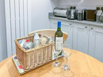 a bottle of wine and two glasses on a table at 3 Catherine Cottages in Keswick