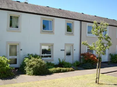 a white house with a tree in front of it at Brundholme Glen in Keswick
