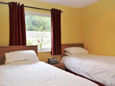 two beds in a room with a window at Brundholme Glen in Keswick
