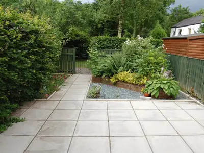 a garden with a stone walkway and some plants at Brundholme Glen in Keswick