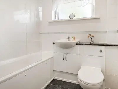 a white bathroom with a toilet and a sink at Blencathra Bank in Keswick