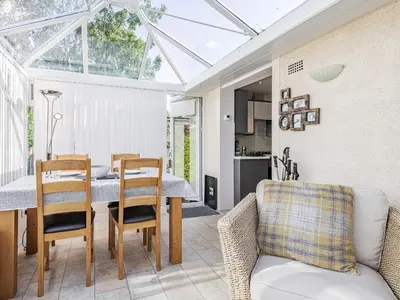 a conservatory with a table and chairs and a dining room at Blencathra Bank in Keswick