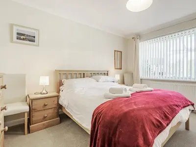 a bedroom with a bed with a red blanket on it at Blencathra Bank in Keswick