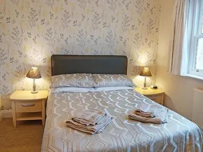 a bedroom with a bed with two lamps on two tables at Carthwaite in Keswick