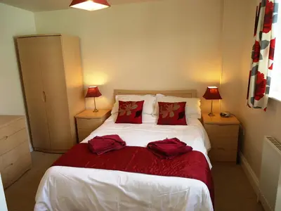 a bedroom with a bed with two red pillows at Carthwaite in Keswick