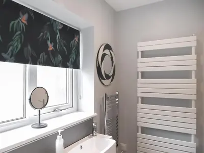 a bathroom with a sink and a mirror and a window at Millie's Cottage in Keswick
