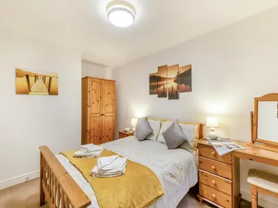 a bedroom with a large bed and a desk at Kissing Gate in Keswick