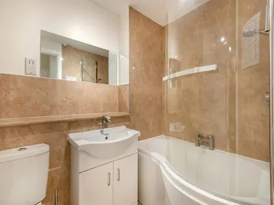 a bathroom with a sink and a tub and a toilet at Kissing Gate in Keswick