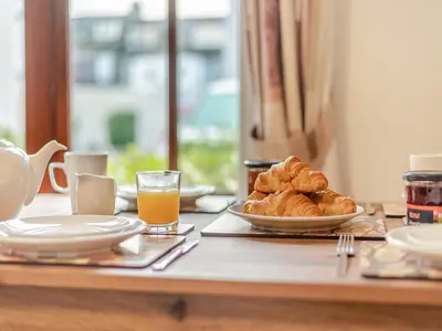 a table with a plate of croissants and orange juice at Kissing Gate in Keswick