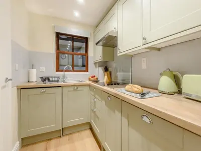 a kitchen with white cabinets and a counter top at Kissing Gate in Keswick