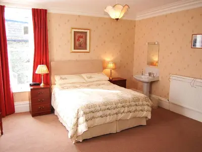 a bedroom with a large bed and a window at Kingstarn in Keswick
