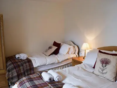 two beds in a room with towels on them at Acorn Lodge Cottage in Keswick