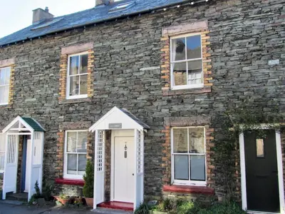a brick house with a white door and windows at Alvamere in Keswick