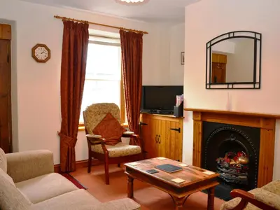 a living room with a fireplace and a mirror at Alvamere in Keswick