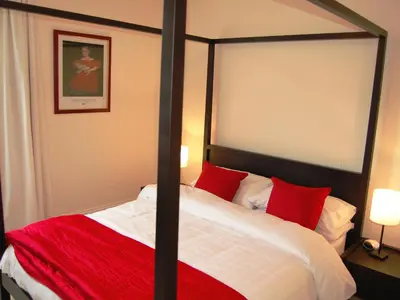 a bedroom with a large bed with red pillows at The Ivy Cottage in Keswick