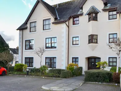 a white house with a red car parked in front of it at Bleaberry- Hewetson Court in Keswick