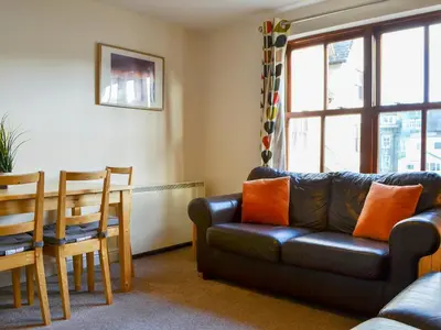 a living room with a couch and a table and chairs at Bleaberry- Hewetson Court in Keswick