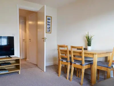 a dining room with a table and chairs and a television at Bleaberry- Hewetson Court in Keswick