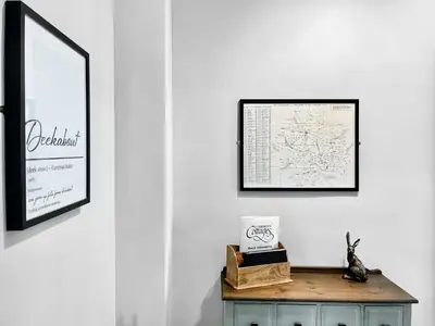 a room with a table with a picture and a mirror at High Style Apartment in Keswick