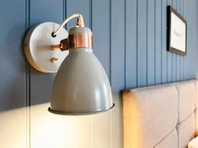 a silver lamp on a table next to a couch at High Style Apartment in Keswick
