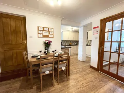 a kitchen and dining room with a wooden table and chairs at Lavender Cottage in Keswick