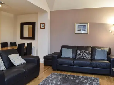 a living room with a black leather couch and chairs at The Old Laundry 1 in Keswick