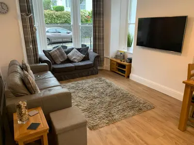a living room with a couch and a flat screen tv at 2 Windsor House in Keswick