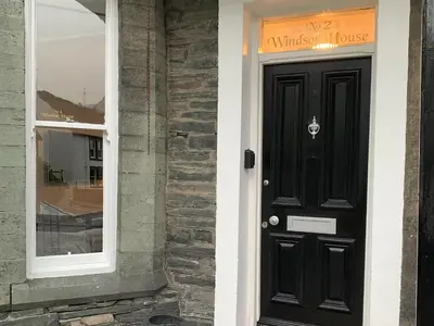 a black door to a house with a window at 2 Windsor House in Keswick