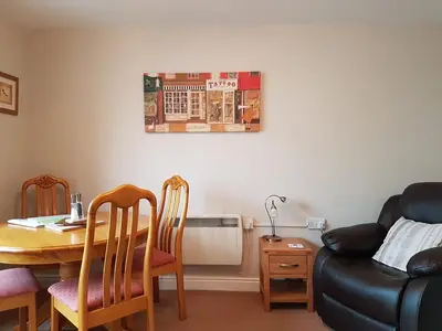 a living room with a table and chairs and a couch at Limetrees in Keswick