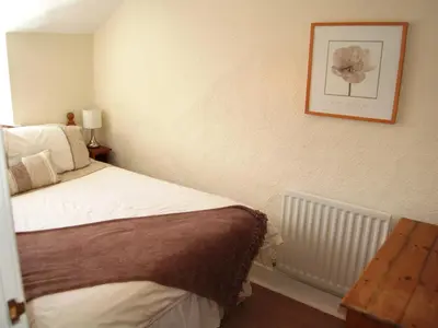 a bedroom with a bed and a picture on the wall at Laal Yan in Keswick