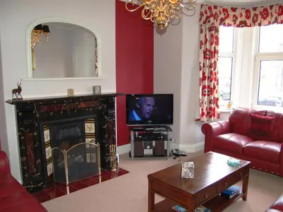 a living room with a fireplace and a television at York House in Keswick
