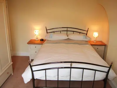 a bedroom with a large bed with two lamps on it at York House in Keswick