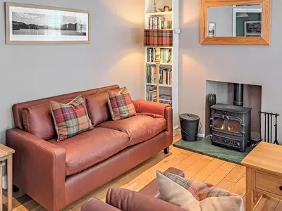 a living room with a leather couch and a wood stove at Hastings in Keswick