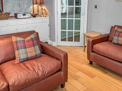 a living room with two leather chairs and a table at Hastings in Keswick