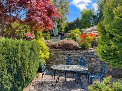 a table and chairs in a garden with flowers at The Croft in Keswick