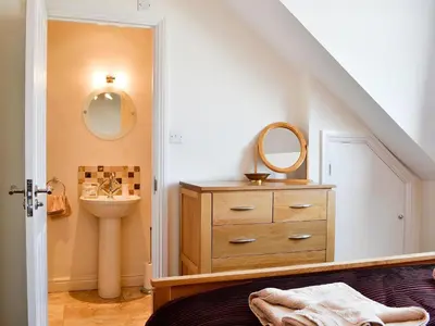 a bathroom with a sink and a mirror and a dresser at Green Ghyll in Keswick