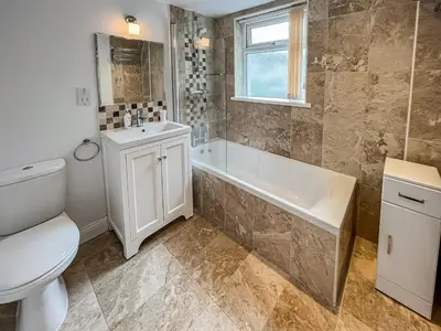 a bathroom with a toilet and a tub and a sink at Green Ghyll in Keswick